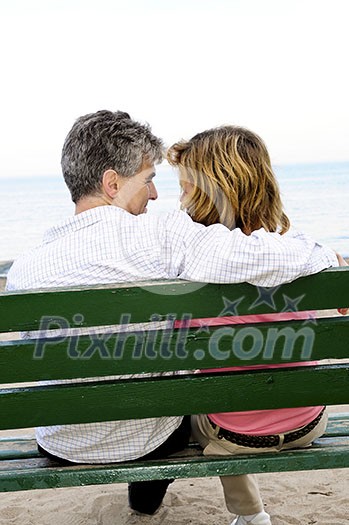 Mature romantic couple on a bench on seashore Mature romantic couple on a bench on seashore