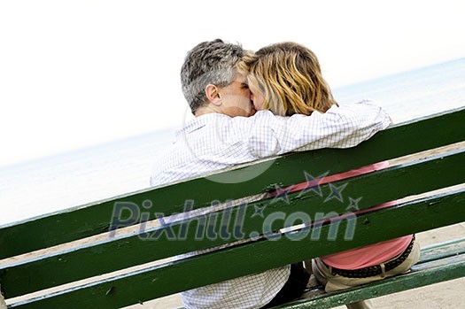 Mature romantic couple on a bench on seashore Mature romantic couple on a bench on seashore