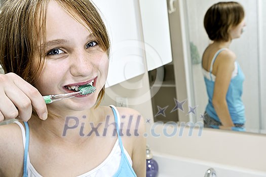 Young girl brushing her teeth in a bathroom Young girl brushing her teeth in a bathroom