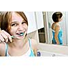 Young girl brushing her teeth in a bathroom