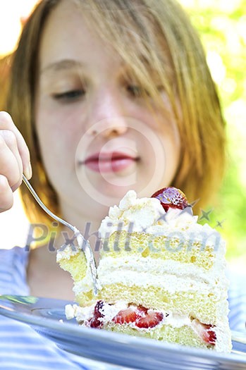 Teenage girl eating a piece of strawberry cake Teenage girl eating a piece of strawberry cake