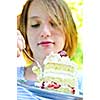 Teenage girl eating a piece of strawberry cake