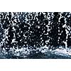 Falling water drops on dark background close up
