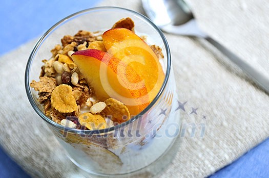 Serving of yogurt with fresh peaches and granola Serving of yogurt with fresh peaches and granola