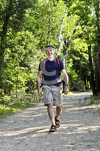 Happy middle aged man walking on a forest trail Happy middle aged man walking on a forest trail