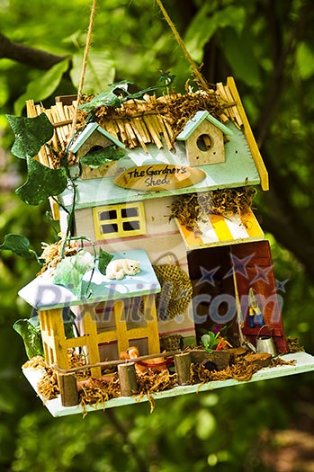 House garden ornament hanging on a tree House garden ornament hanging on a tree