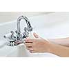 Child washing hands with soap under running water