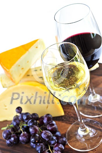 Wineglasses with red and white wine and assorted cheeses Wineglasses with red and white wine and assorted cheeses