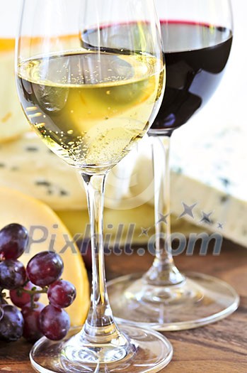 Wineglasses with red and white wine and assorted cheeses Wineglasses with red and white wine and assorted cheeses