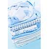 Stack of blue infant clothing for baby shower