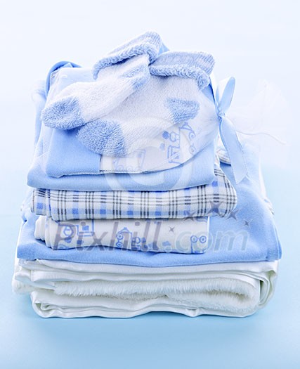 Stack of boy infant clothing for baby shower on blue background Stack of boy infant clothing for baby shower on blue background