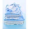 Stack of boy infant clothing for baby shower on blue background
