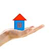 Hand holding wooden block house isolated on white background