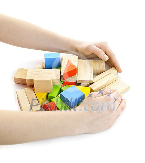 Hands gathering pile of wooden block toys isolated on white Hands gathering pile of wooden block toys isolated on white