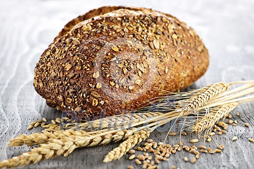 Loaf of fresh baked multigrain bread with grain ears Loaf of fresh baked multigrain bread with grain ears