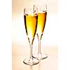 Two full champagne flutes with sparkling wine