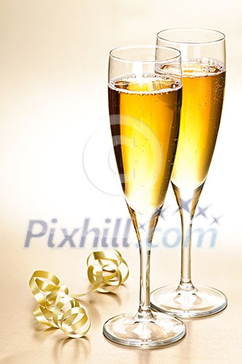 Two full champagne flutes with sparkling wine and ribbon Two full champagne flutes with sparkling wine and ribbon