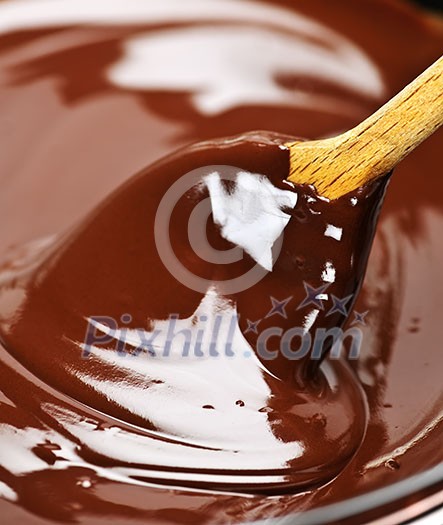 Wooden spoon stirring soft melted rich chocolate Wooden spoon stirring soft melted rich chocolate