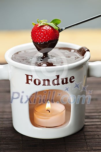 Strawberry dipped in delicious melted chocolate fondue Strawberry dipped in delicious melted chocolate fondue