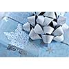 Christmas gift box wrapped in blue paper with silver ribbon close up