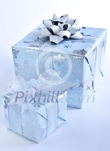 Two christmas gift boxes wrapped in blue paper with silver ribbon Two christmas gift boxes wrapped in blue paper with silver ribbon