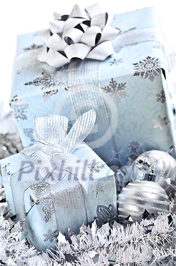 Wrapped gift boxes with silver Christmas ornaments on white background Wrapped gift boxes with silver Christmas ornaments on white background