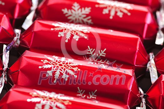 Closeup of many red Christmas crackers in a row Closeup of many red Christmas crackers in a row