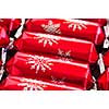 Closeup of many red Christmas crackers in a row