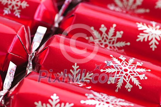Closeup of many red Christmas crackers in a row