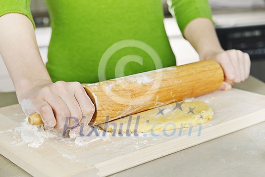 Spreading out cookie dough with wooden rolling pin