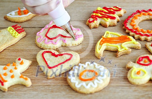 Decorating homemade shortbread cookies with icing from piping bag Decorating homemade shortbread cookies with icing from piping bag