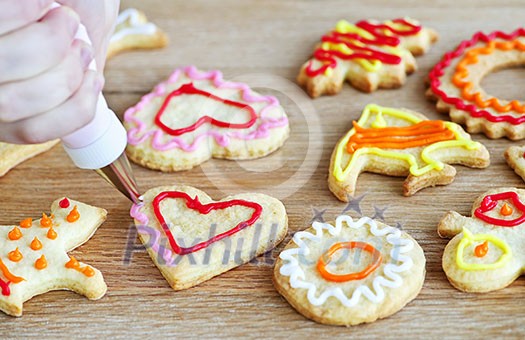Decorating homemade shortbread cookies with icing from piping bag Decorating homemade shortbread cookies with icing from piping bag