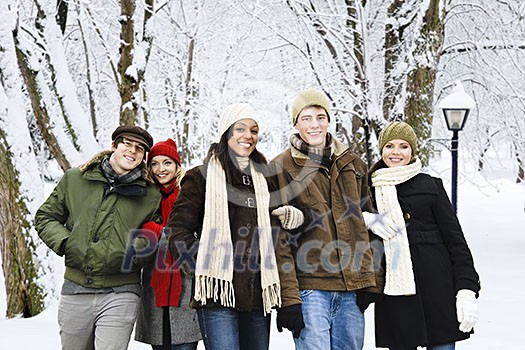 Group of diverse young friends walking outdoors in winter park Group of diverse young friends walking outdoors in winter park