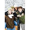 Group of young friends giving piggy back rides outdoors in winter