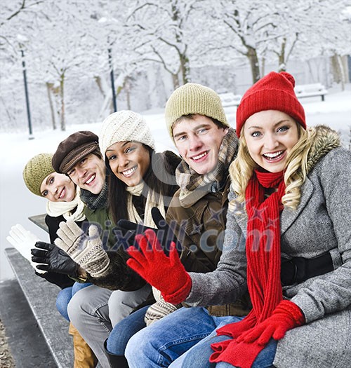 Group of diverse young friends waving hello outdoors in winter Group of diverse young friends waving hello outdoors in winter