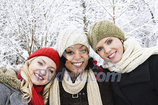 Group of three diverse young girl friends outdoors in winter Group of three diverse young girl friends outdoors in winter