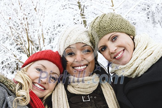 Group of three diverse young girl friends outdoors in winter Group of three diverse young girl friends outdoors in winter