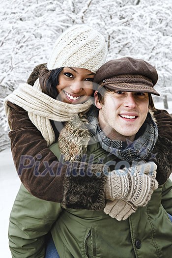 Portrait of couple having piggyback ride outdoors in winter Portrait of couple having piggyback ride outdoors in winter