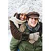 Portrait of couple having piggyback ride outdoors in winter