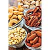 Almonds, cashews pistachio and pine nuts in glass bowls