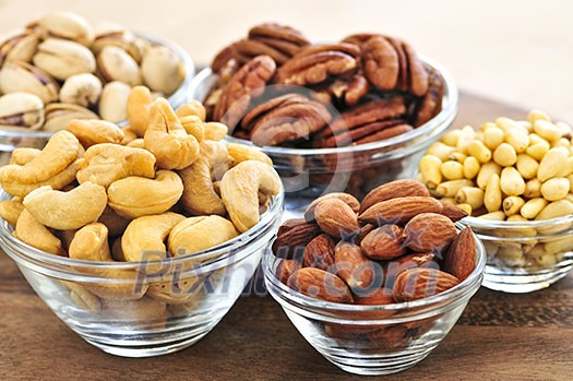 Almonds, cashews pistachio and pine nuts in glass bowls Almonds, cashews pistachio and pine nuts in glass bowls
