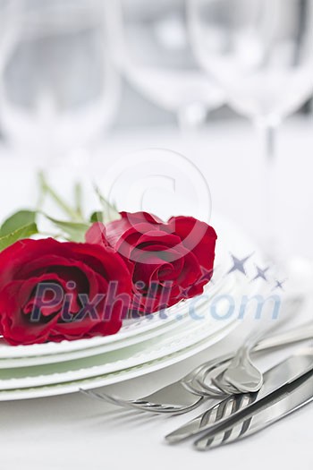 Romantic table setting for two with roses plates and cutlery Romantic table setting for two with roses plates and cutlery