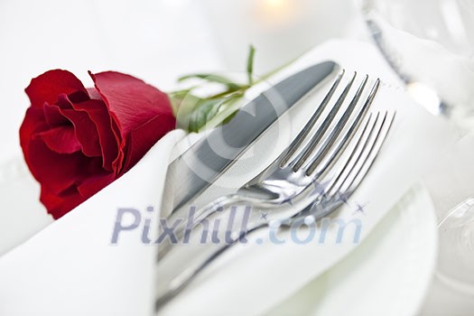 Romantic table setting with rose plates and cutlery