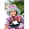 Portrait of happy teenage girl holding snow in gloves