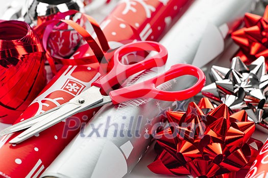 Rolls of Christmas wrapping paper with ribbons, bows and scissors Rolls of Christmas wrapping paper with ribbons, bows and scissors