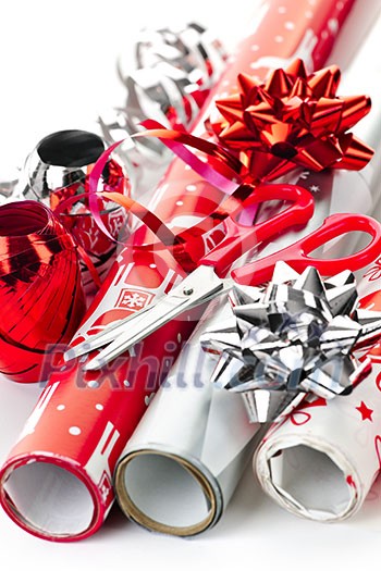 Rolls of Christmas wrapping paper with ribbons, bows and scissors Rolls of Christmas wrapping paper with ribbons, bows and scissors
