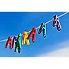 Colorful clothes pegs on line against blue sky