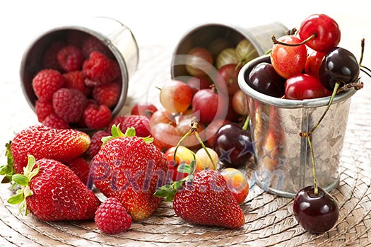 Assorted summer fruits and berries in metal pails Assorted summer fruits and berries in metal pails