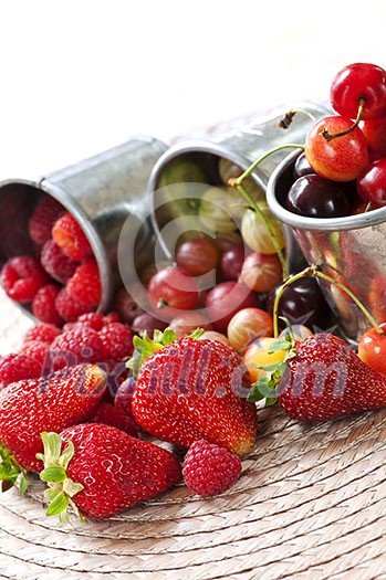 Assorted summer fruits and berries in metal pails Assorted summer fruits and berries in metal pails