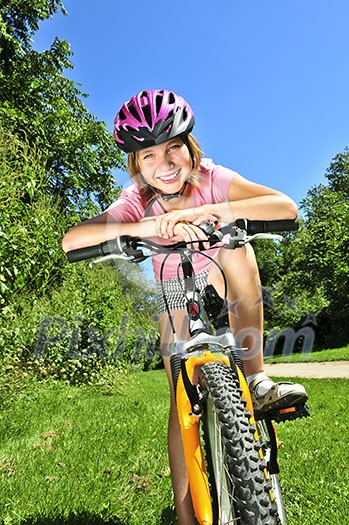 Portrait of a teenage girl on a bicycle in summer park outdoors Portrait of a teenage girl on a bicycle in summer park outdoors